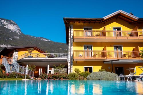 a yellow building with a swimming pool in front of it at Maso Agritur Santa Lucia in Dro