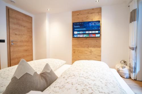 a bedroom with two beds and a tv on the wall at Ferienhaus Leite Häusl in Sankt Jodok am Brenner