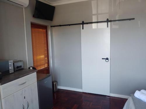 een keuken met een glazen schuifdeur en een koelkast bij Boutique Hotel on the Bay in Humewood