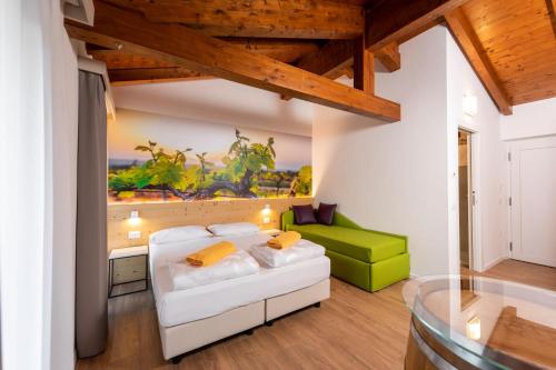 a living room with a white couch and a green chair at Maso Agritur Santa Lucia in Dro