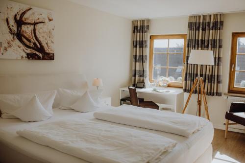 ein weißes Schlafzimmer mit einem Bett, einem Schreibtisch und einem Fenster in der Unterkunft Hotel Havelser Hof in Garbsen