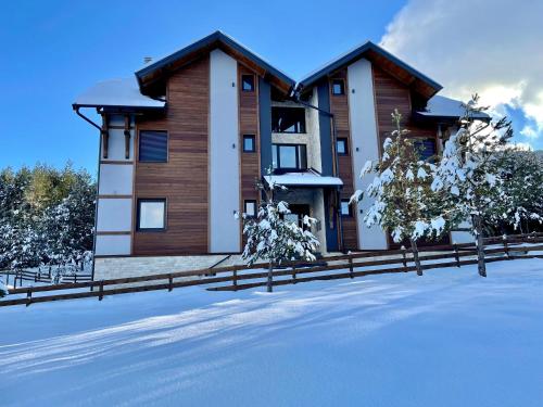 TornikにあるVila Nordika Tornikの雪の中の柵のある家