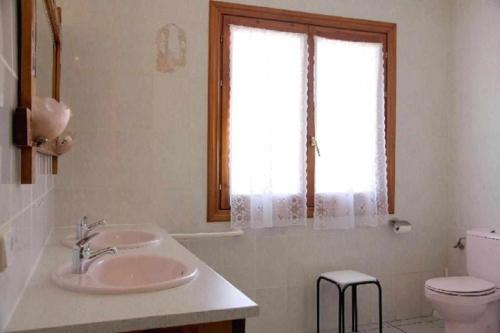 baño con lavabo y aseo y ventana en Casa Rural Mantxoalorra en Ochagavía