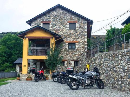 a group of motorcycles parked in front of a stone building at El Jardí Casa rural ideal para familias y grupos in Arfa