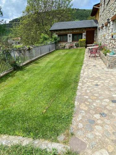 a yard with a fence and a lawn with a bench at El Jardí Casa rural ideal para familias y grupos in Arfa