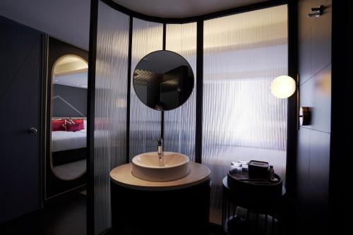 a bathroom with a sink and a mirror at Awann Sewu Boutique Hotel and Suite Semarang in Semarang