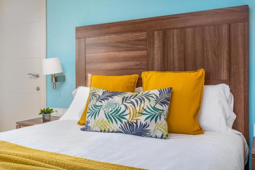 1 cama con 2 almohadas y cabecero de madera en Kronos on the Beach suite 3, en Barcelona