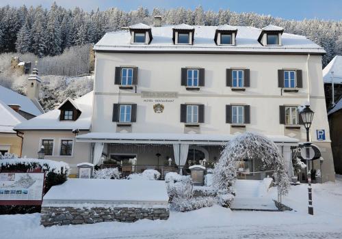 a large building with an arch in the snow at Villa Bucher - Metnitztalerhof in Friesach