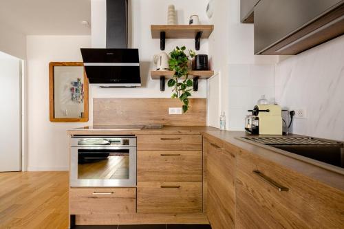 eine Küche mit Holzschränken und einem Herd in der Unterkunft 3 p 60 M2 Lesapparts Paris-Clichy terrasse équipée et wifi gratuit in Clichy
