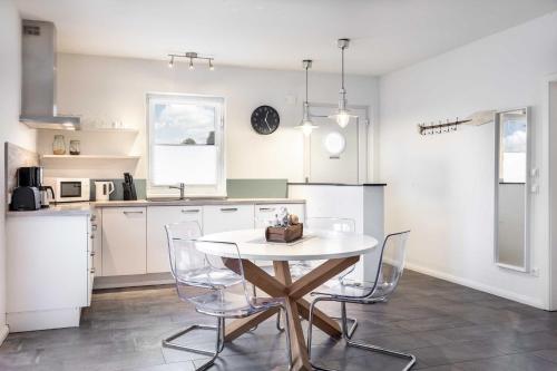 a kitchen with a table and chairs in a room at Salzhaff StrandHaeuser mit Kamin u in Pepelow