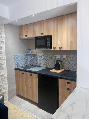 une cuisine avec un évier et un micro-ondes dans l'établissement La tour 2: Appart neuf au cœur de la petite venise, à LʼIsle-sur-la-Sorgue