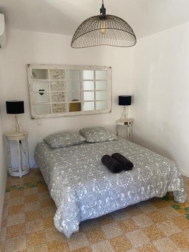 un letto in una camera da letto con due tavoli e due lampade di La tour 2: Appart neuf au cœur de la petite venise a LʼIsle-sur-la-Sorgue