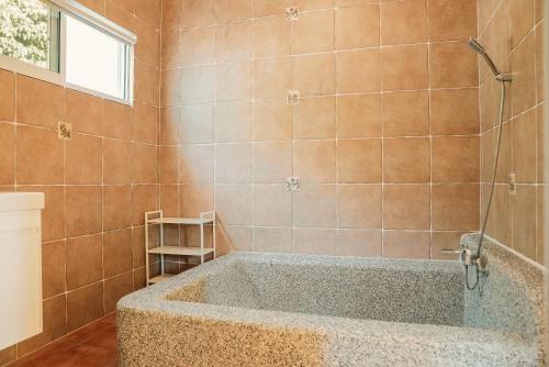 ein Bad mit einer großen Badewanne in einem Zimmer in der Unterkunft Linwu 05 墾丁包棟民宿 in Eluan