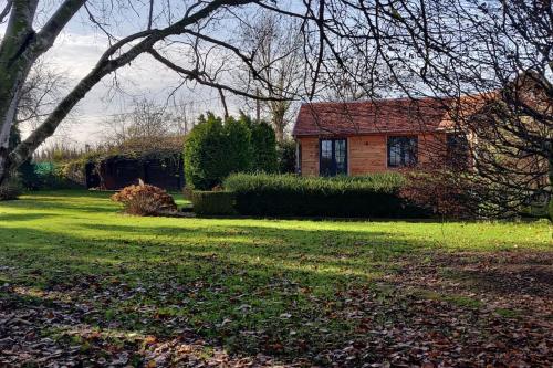 a house in a yard with a green lawn at Chalet Duras in Sint-Truiden