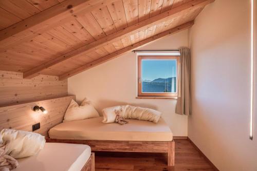 a small room with a bed and a window at Brugghof Apartement Lärche in San Felice