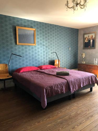 a bedroom with a large bed with a purple blanket at Dealettante in Bétaucourt