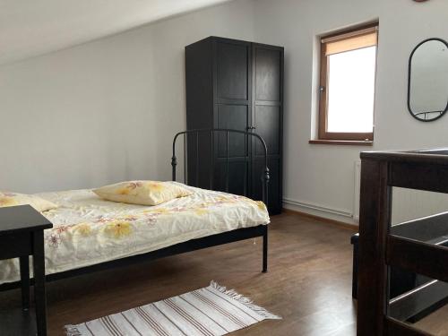 - une chambre avec un lit et une armoire noire dans l'établissement Ambassador's Villa, à Bran