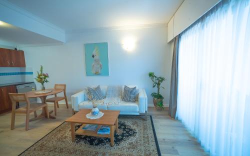 a living room with a couch and a table at MARGARET FOREST RETREAT Apartment 129 - Located within Margaret Forest, in the heart of the town centre of Margaret River, spa apartment! in Margaret River Town