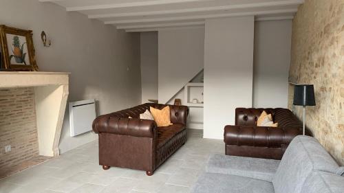 a living room with two leather chairs and a couch at La Source in Saint-Martin-lʼArs