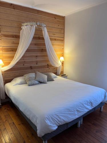 a bedroom with a large white bed with a canopy at L'hostellerie de Sèvremont in Saint-Michel-Mont-Mercure