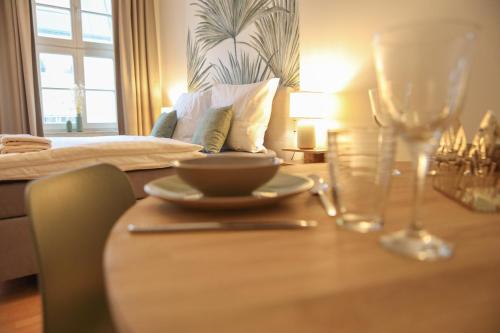 a table with a plate of food and a wine glass at Sleepwell Apartment - Emilienblick in Leipzig