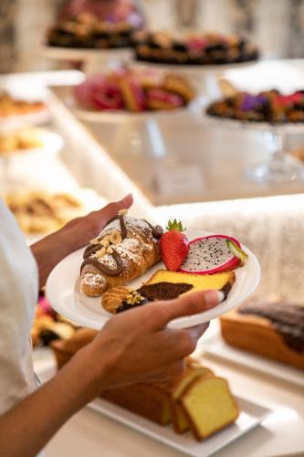 a person holding a plate of food on a table at Hotel Mazzanti in Milano Marittima