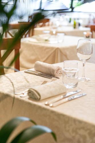 a table with glasses and silverware on top of it at Hotel Mazzanti in Milano Marittima