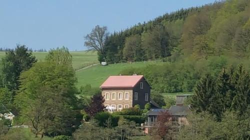 a large house in the middle of a green hill at die alte schule-studio in Alfersteg