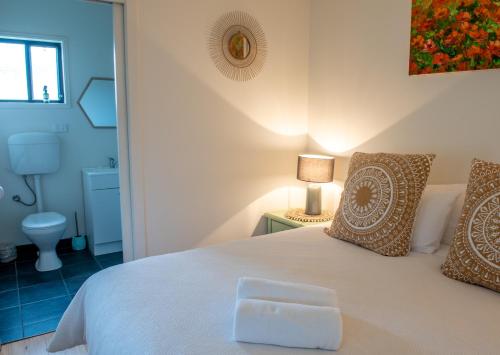 a bedroom with a white bed and a bathroom at Bower On Becket - Couples Retreat in Rye