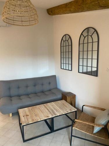 sala de estar con sofá azul y mesa en La tour 3: Appart au cœur de la petite Venise, en LʼIsle-sur-la-Sorgue
