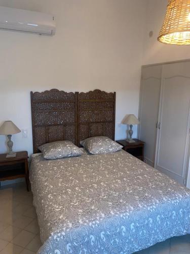 1 dormitorio con 1 cama grande y 2 lámparas en las mesas en La tour 3: Appart au cœur de la petite Venise, en LʼIsle-sur-la-Sorgue