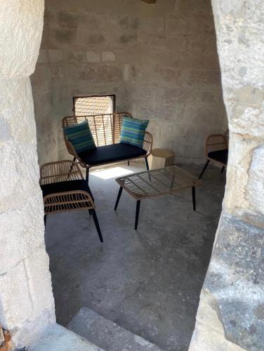 un grupo de sillas y una mesa en una habitación en La tour 3: Appart au cœur de la petite Venise, en LʼIsle-sur-la-Sorgue