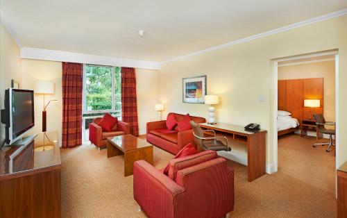 a living room with red furniture in a hotel room at Orida Maidstone in Maidstone