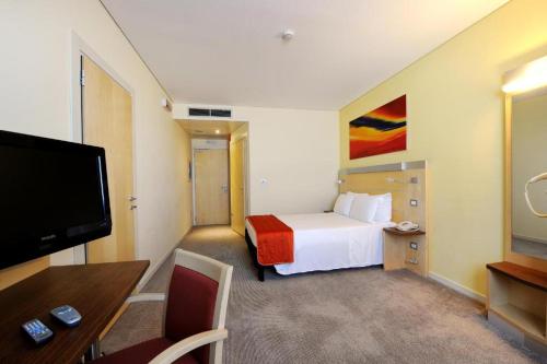 a hotel room with a bed and a flat screen tv at Bes Hotel Bergamo Ovest in Mozzo
