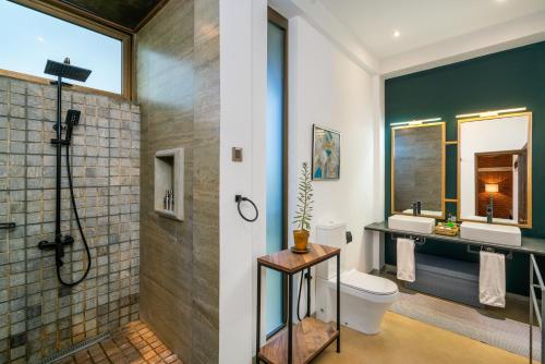 a bathroom with a toilet and two sinks and a shower at Wild Culture Yala in Yala