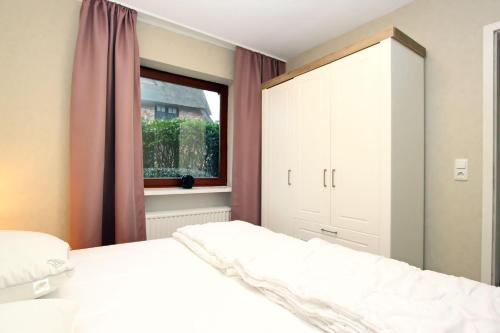 ヴェニングシュテットにあるAm-Friesenringのベッドルーム(白いベッド1台、窓付)