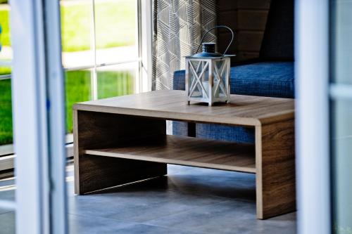 a wooden coffee table in front of a couch at Domki Na Brackiej in Pobierowo