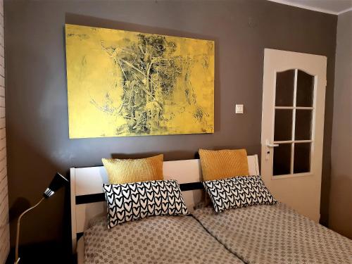 a bedroom with a bed and a painting on the wall at Apartament blisko morza - Yellow Stone in Gdańsk