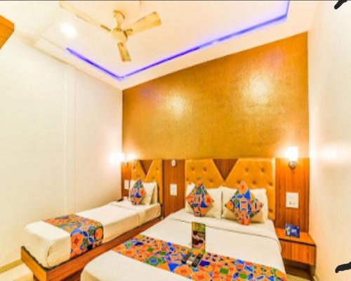 a bedroom with two beds and a ceiling at Hotel BENTLY Terminal-2 in Mumbai