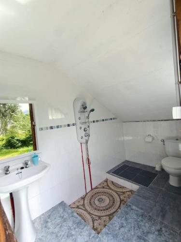 a white bathroom with a sink and a toilet at Viviendas vacacionales La Casona de Tresniñin in Nava