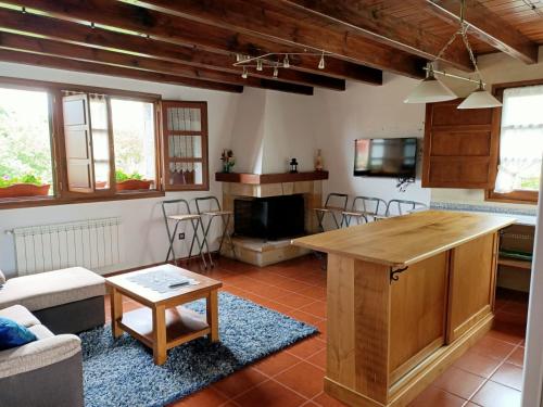 uma sala de estar com uma mesa de madeira e cadeiras em Viviendas vacacionales La Casona de Tresniñin em Nava