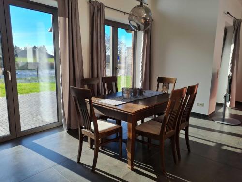 a dining room with a wooden table and chairs at Ruegen Ferienhaus 300 in Sehlen