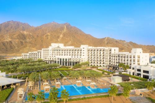 een luchtzicht op een resort met een zwembad en palmbomen bij InterContinental Fujairah Resort, an IHG Hotel in Al Aqah