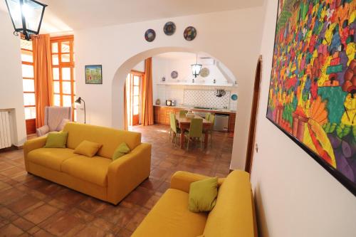 a living room with a yellow couch and a kitchen at Relais Delle Rose in Lecce