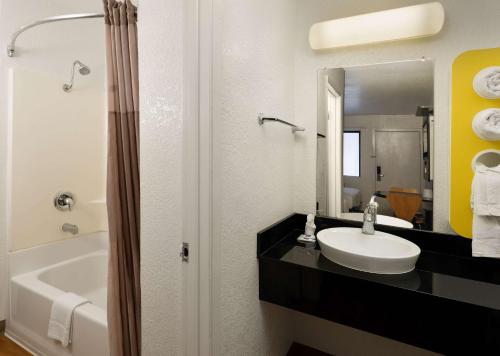 a bathroom with a sink and a tub and a mirror at Motel 6-Camarillo, CA in Camarillo