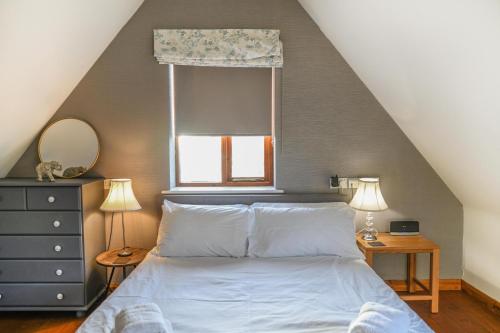 a bedroom with a large bed with a window at Little Dene Lodge in Pakenham