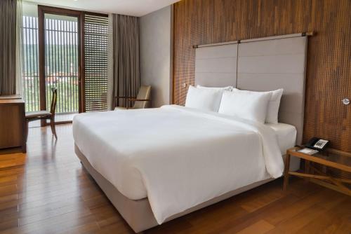 a large white bed in a hotel room at Radisson Resort and Spa Lonavala in Lonavala