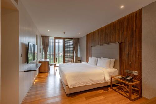 a bedroom with a large bed and a wooden wall at Radisson Resort and Spa Lonavala in Lonavala