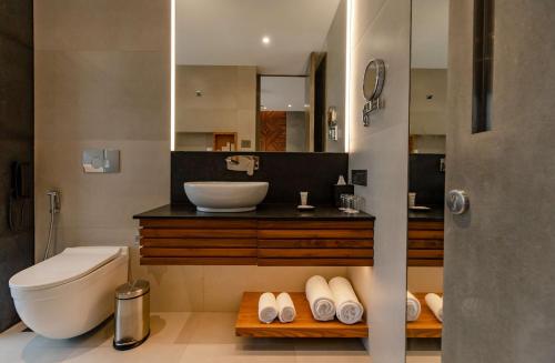 a bathroom with a sink and a toilet and a mirror at Radisson Resort and Spa Lonavala in Lonavala