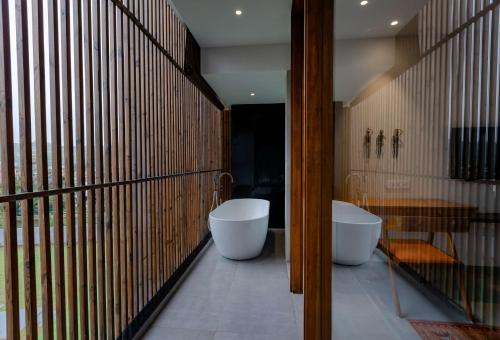a bathroom with two white tubs in a room at Radisson Resort and Spa Lonavala in Lonavala